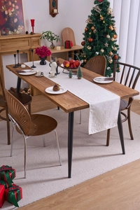 Close-up of white jacquard table runner with floral patterns on wooden table for Christmas