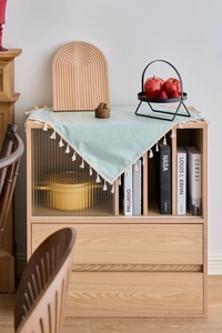Detail of mint green TPU tablecloth with elegant white tassels on a wooden table