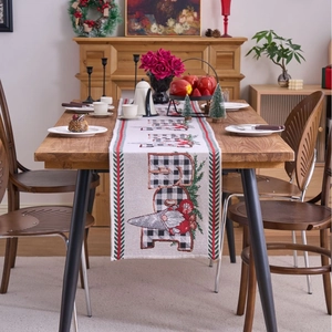 Christmas Believe Gnome table runner with buffalo plaid pattern on rustic wooden dining table