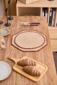 Detalle de manteles de yute trenzado con borde de ganchillo marrón y textura natural rústica