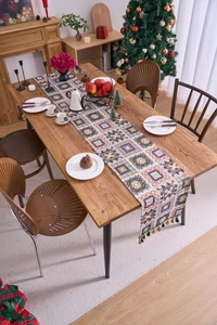Detail of bohemian jacquard table runner with geometric patterns and fringe tassels