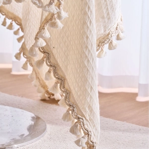 Creamy white waffle weave tablecloth with decorative tassel edges for home decor
