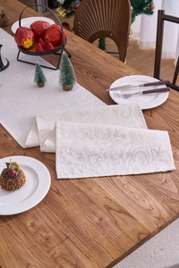 Detail of elegant ivory jacquard table runner with intricate paisley floral pattern