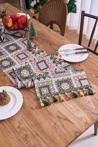 Detailed close-up of woven Christmas table runner with tassels and geometric patterns