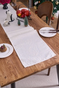Close-up of off-white Christmas table runner with intricate paisley jacquard pattern
