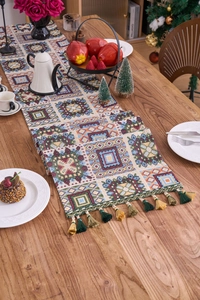 Close-up of geometric jacquard patterns and two-tone tassels on a woven table runner