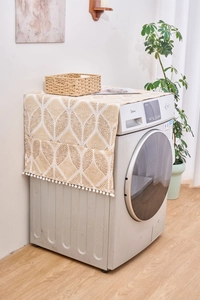 Détail de la housse géométrique pour machine à laver avec poches et pompons blancs