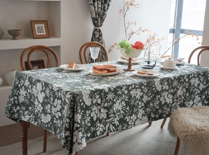 Détail de la nappe fleurie vert foncé avec motifs blancs et texture en lin et coton