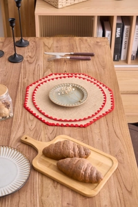 Detalle del mantel individual octogonal de yute con borde decorativo de ganchillo rojo