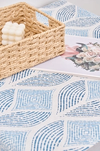 Vue détaillée du chemin de table géométrique avec panier tressé et bougie
