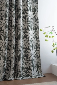 Detail of dark green chenille curtain with tropical palm leaf jacquard and heavy drape