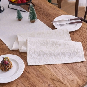 Elegant ivory white jacquard table runner with Paisley pattern on dark wood table