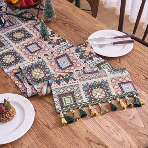 Bohemian jacquard table runner with geometric patterns and colorful tassels on wood table