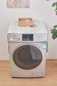 Détail de la housse anti-poussière à vagues géométriques avec pompons sur lave-linge frontal