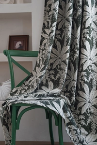 Detailed texture of dark green chenille curtain fabric with white palm leaf jacquard