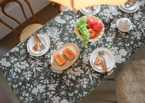 Détail d'une nappe en jacquard vert foncé avec texture de lin et motifs floraux