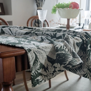 Close-up of heavy jacquard tablecloth with deep green tropical palm leaf pattern