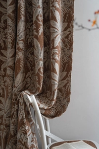Dettaglio della tenda pesante in ciniglia marrone caramello con texture jacquard foglia