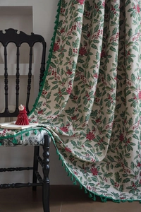 Close-up of holly berry jacquard fabric with festive green tassels for home decor