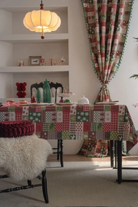 Detail of Christmas tablecloth and curtains with reindeer patterns and fringe tassels
