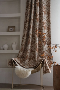 Dettaglio tenda in ciniglia marrone con jacquard a foglia di palma su sedia dorata