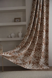 Dettaglio della tenda in ciniglia terracotta con trama jacquard di foglie tropicali bianche