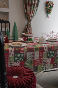Detailed view of jacquard Christmas tablecloth featuring gingerbread men and holiday patterns