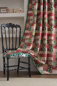 Close-up of Christmas curtains with festive patterns, plaid design, and green tassels