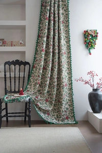 Detail of Christmas holly berry jacquard curtain fabric with decorative green fringe edge