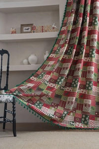 Detail of Christmas curtain featuring reindeer motifs and green tassel ball fringe trim