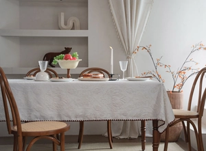 Detailed close-up of white 3D jacquard tablecloth with elegant scalloped edges