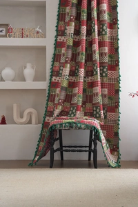 Close-up of Christmas curtains featuring gingerbread man prints and green tassel edges