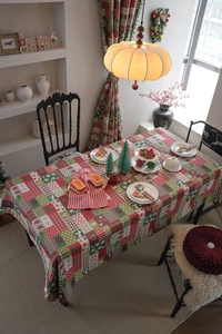 Detail of Christmas tablecloth featuring festive reindeer, tree and snowflake patterns