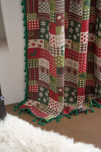 Close-up of Christmas curtains with gingerbread man pattern and green fringe detail