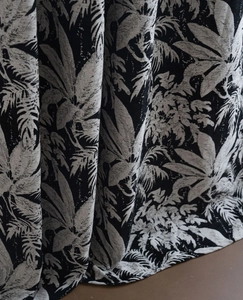 Detail of chenille fabric with black botanical leaf jacquard pattern and soft texture