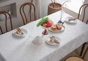 Close-up of white embossed jacquard tablecloth with luxury damask floral pattern