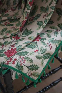 Detail of Christmas holly jacquard fabric with red berries and green tassels