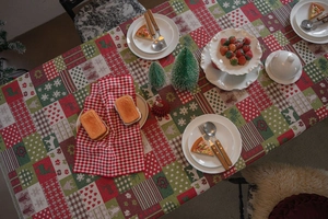 Flat lay of Christmas tablecloth featuring gingerbread man, reindeer and snowflake patterns