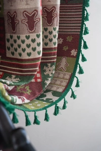 Detail of Christmas gingerbread man jacquard fabric with festive green fringe tassels