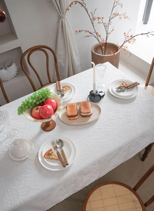 Detailed overhead view of white textured floral jacquard tablecloth for dining tables