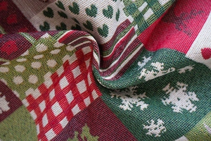 Detail of Christmas jacquard fabric with red hearts and green snowflake textures
