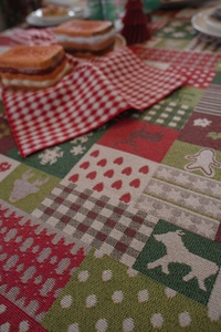 Macro shot of jacquard Christmas tablecloth featuring reindeer and gingerbread patterns