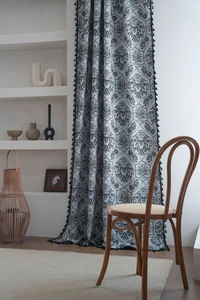 Detailed close-up of retro black damascus jacquard pattern with fringe tassel trim