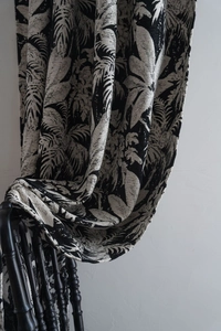Close-up of tropical palm leaf pattern on thick black and white jacquard curtain fabric