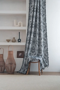 Detail of bohemian black damask floral pattern curtain with decorative tassels