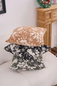 Close-up of stacked chenille jacquard pillow covers with floral patterns on a white sofa