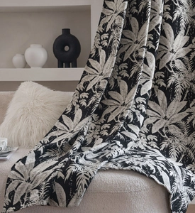 Close-up of thick chenille curtain fabric featuring black and white tropical leaf patterns