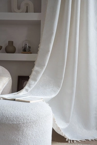 Detailed macro view of the cream white embossed jacquard fabric with elegant tassel trim