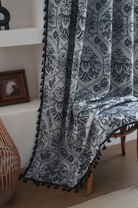Detailed view of grey blue curtains with black damascus jacquard and fringe trim