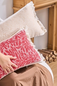 Dettaglio macro della federa jacquard che mostra trame floreali tessute e bordi con frange
